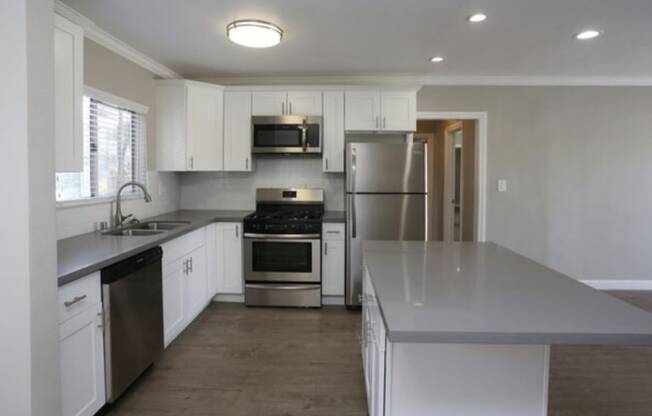 A kitchen with white cabinets and stainless steel appliances.