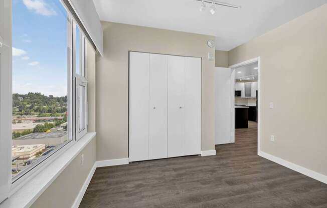 A room with a large window and a white door.