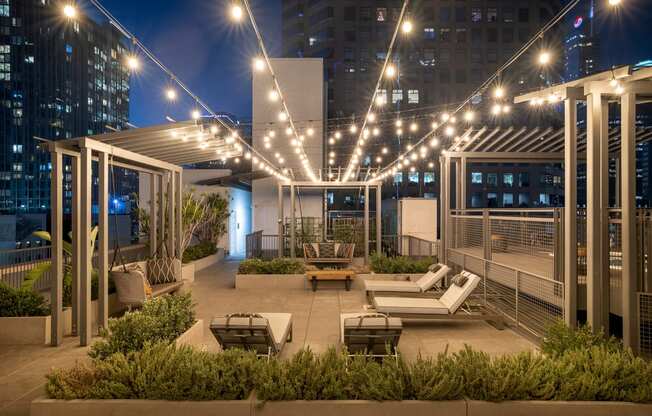 a rooftop patio with lounge furniture and lights