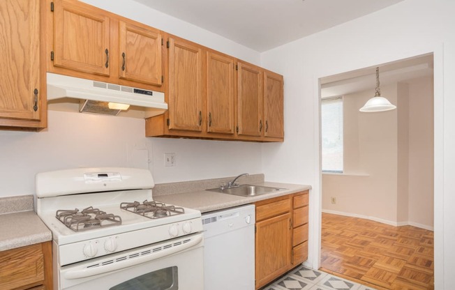 a kitchen with white appliances and wooden cabinets and a white stove