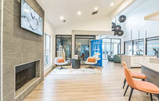 A modern office space with a fireplace, chairs, and a TV.