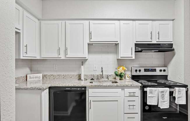 A kitchen with white cabinets and appliances.