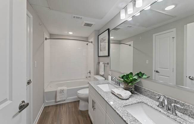 A bathroom with a white tub, toilet, and sink.