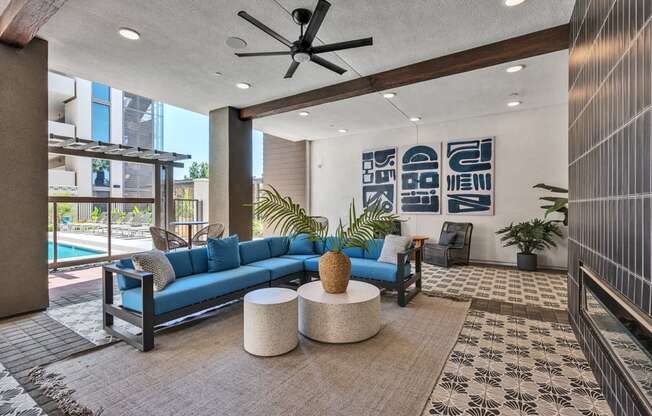 A living room with a blue couch and a ceiling fan.