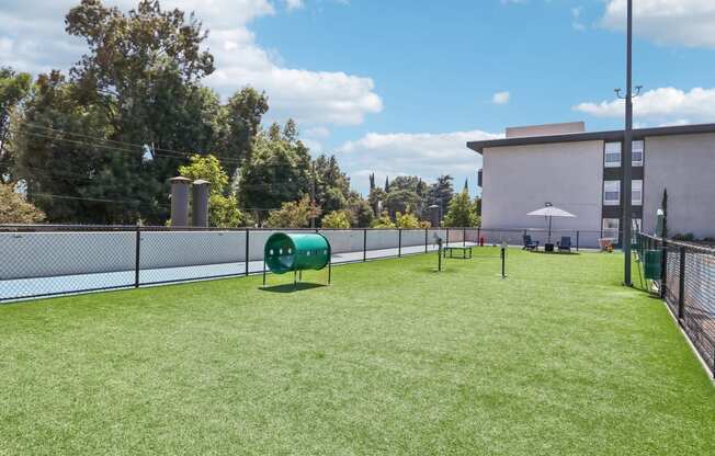 a dog park on the roof of a building with a tennis court