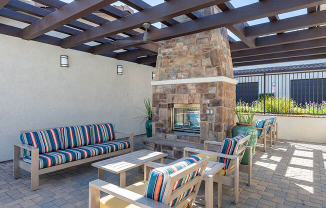 a patio with a fireplace and chairs and tables