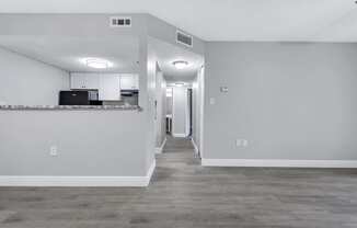 the living room and kitchen of an empty apartment