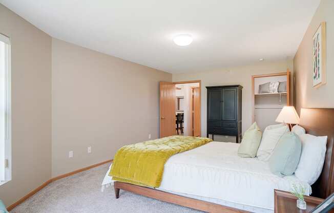 Furnished bedroom with a bed and a yellow blanket