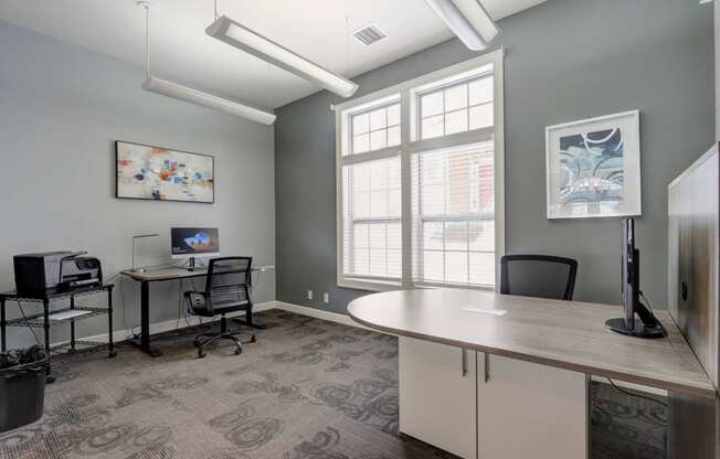 a conference room with desks and chairs and a large window