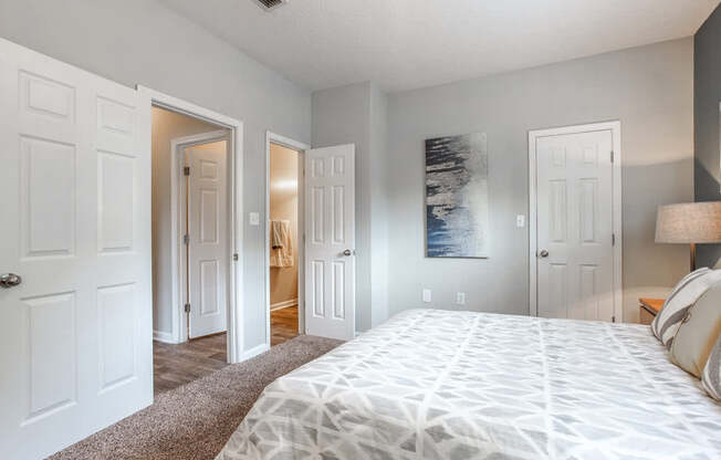 A bedroom with a large bed and a painting on the wall.