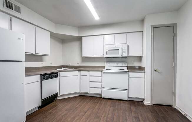 a kitchen with white cabinets and white appliances