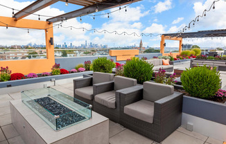 a seating area on the rooftop of a building with a view of the philadelphia skyline
