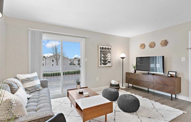 a living room with a couch and a tv in front of a sliding glass door