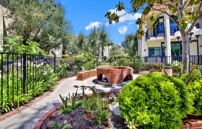 a patio with a fire pit and plants in a garden at Willow Tree Apartments, Torrance