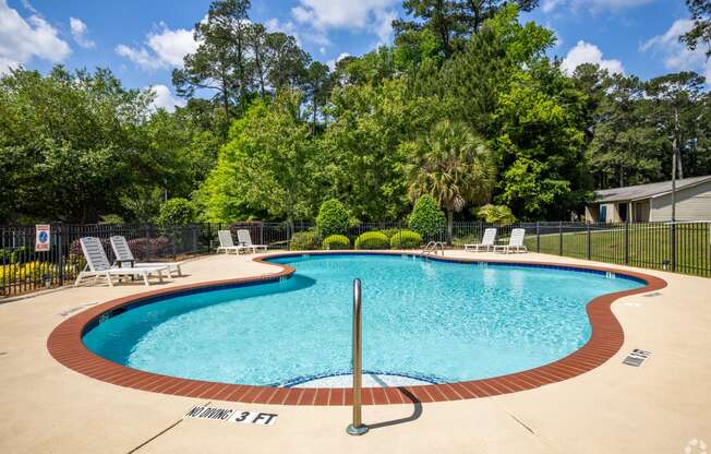 a resort style pool with chairs and a fence around it