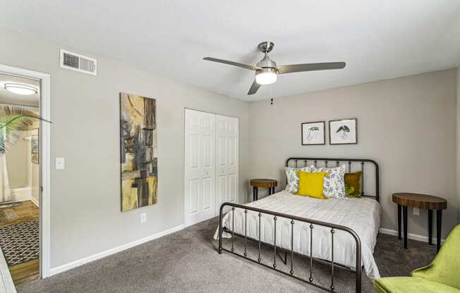 A bedroom with a bed, a chair, and a painting on the wall.