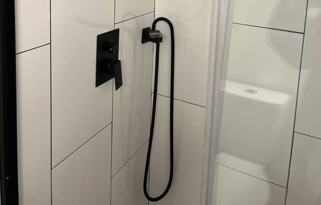 The Retreat at Indian Lake - Renovated Studio Shower with White Tile and Black Hardware