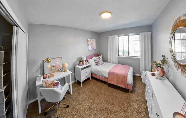 a bedroom with a bed and a desk and a window