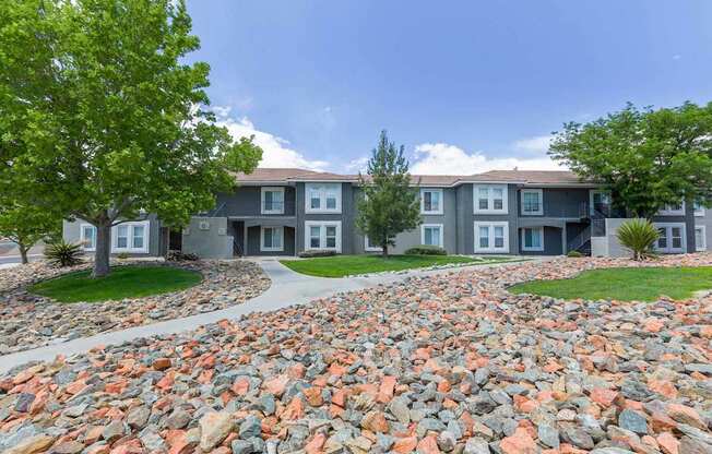 A large grey building with a stone pathway in front.