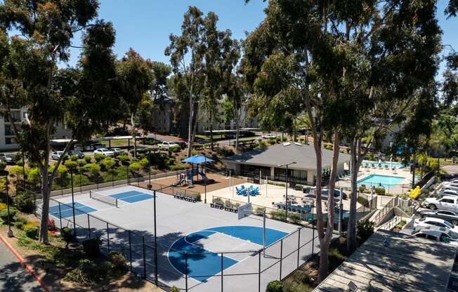 an aerial view of a tennis court with pools and trees