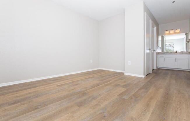A room with wooden flooring and white walls.