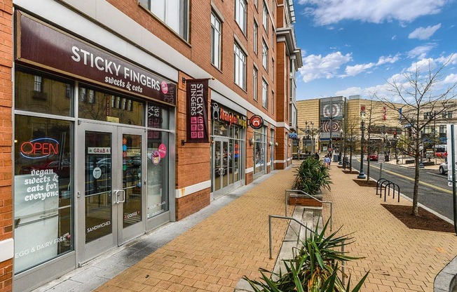 a city street with a brick sidewalk in front of a store