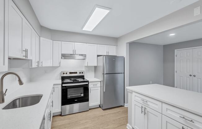 a large kitchen with white cabinets and stainless steel appliances