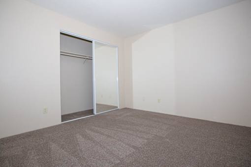 A room with a carpeted floor and a white door.