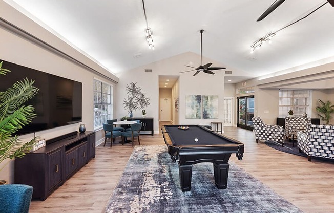 Community Clubhouse with Lounge Furniture and Pool Table Area at Vue at Baymeadows Apartments in Jacksonville, FL.