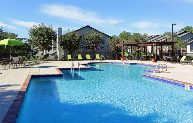 A large swimming pool with a sunny sky in the background.