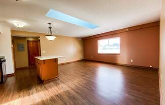 an empty living room with wood floors and a table