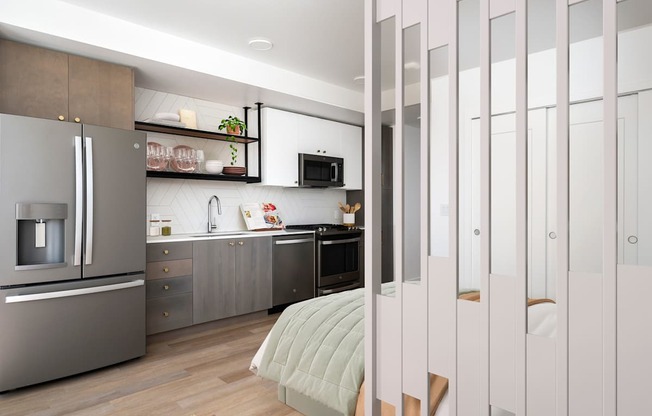 A modern kitchen with a refrigerator, microwave, and oven.