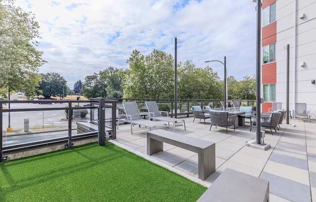 A patio with a bench, chairs, and a table.