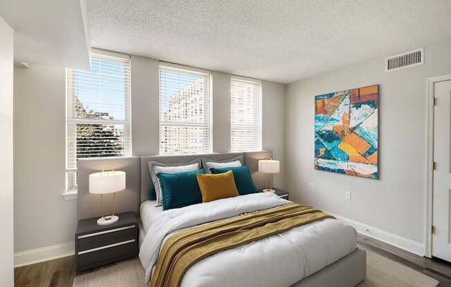 A bedroom with a large bed and a painting on the wall