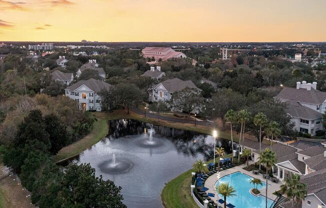 an aerial view of a swimming pool and fountain at sunset