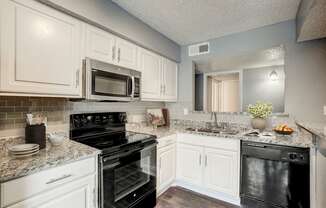 a kitchen with black appliances and white cabinets