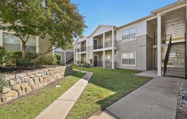 our apartments have a spacious courtyard with grass and a stone wall