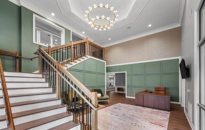 Grand clubhouse lobby with a statement staircase, custom millwork, and refined finishes that create a welcoming first impression upon arrival.