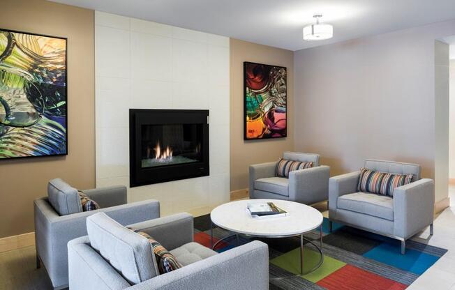 Community space with four armchairs surrounding small table, fireplace in the wall