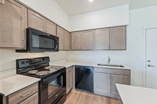 an empty kitchen with stainless steel appliances and wooden cabinetsat Gateway Apartments, Washington