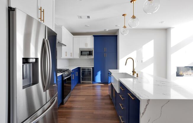 a kitchen with stainless steel appliances and blue cabinets