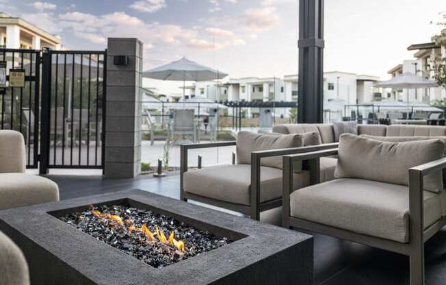 a patio with couches and chairs and a fire pit