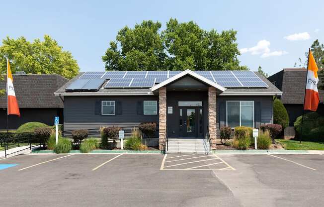 A building with solar panels on the roof and flags on the front.