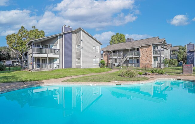 A swimming pool in front of apartment buildings at Laurel Parc apartments in Shreveport, LA.