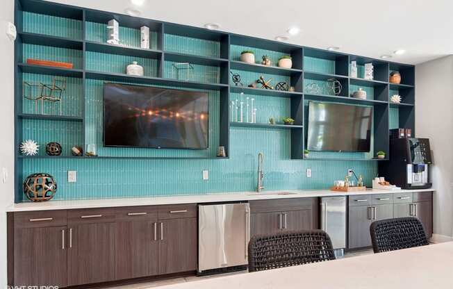 a kitchen with blue cabinets and a tv on the wall