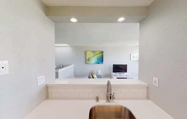 a kitchen with a sink and a tv in the background