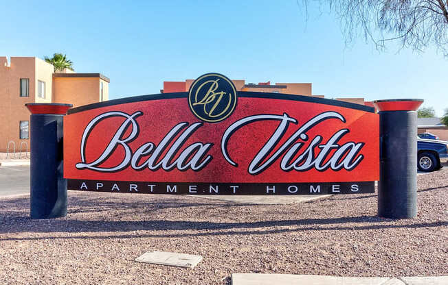 A sign for Bella Vista Apartment Homes is displayed in front of a building.