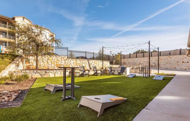 a yard with lawn furniture and tables and a stone wall