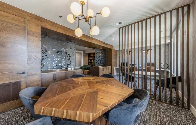 A wooden table with chairs and a chandelier in a room.