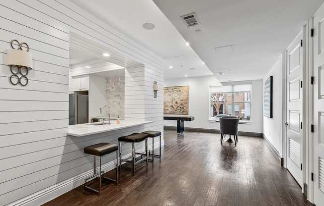 A long, narrow room with a bar area and a dining table.